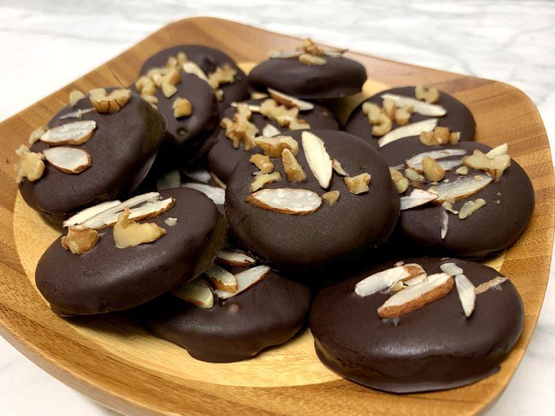 This is a picture of Vegan Chocolate Mint Almond Cookies on a wooden cutting board and a table top.
