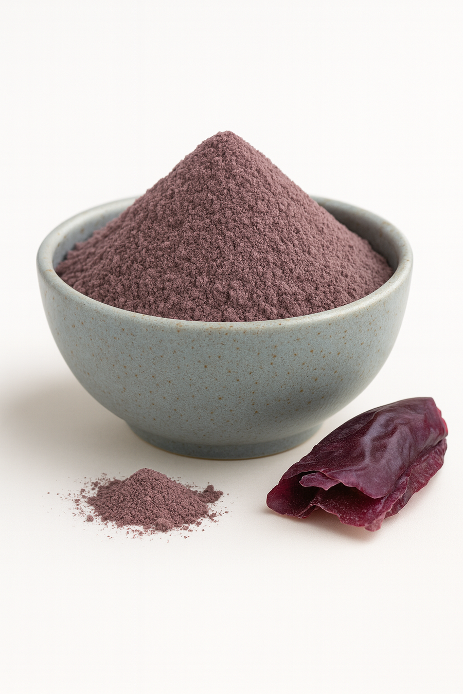 Organic dulse powder mounded in a plain neutral bowl on a white background, fine reddish-brown texture, evenly lit for true color.