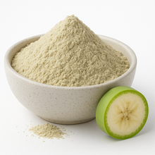 Organic green banana powder mounded in a neutral speckled bowl  on a white background.