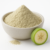 Organic green banana powder mounded in a neutral speckled bowl  on a white background.