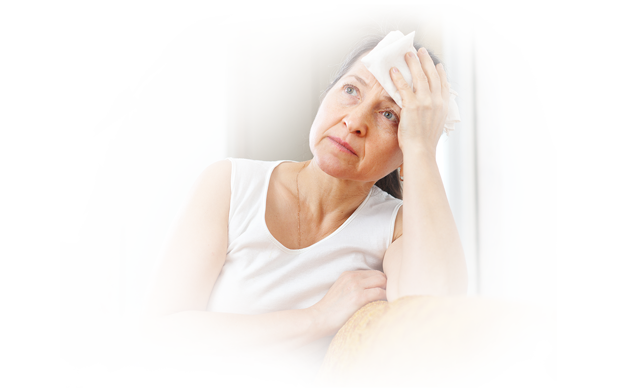 Image of midlife woman experiencing a hot flash with cooling towel on her forehead.
