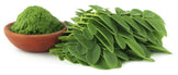 Moringa Leaf Powder in brown bowl and a pile of moringa leave