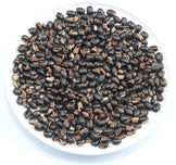 Image of a white plate full of black Mucuna Pruriens Seeds