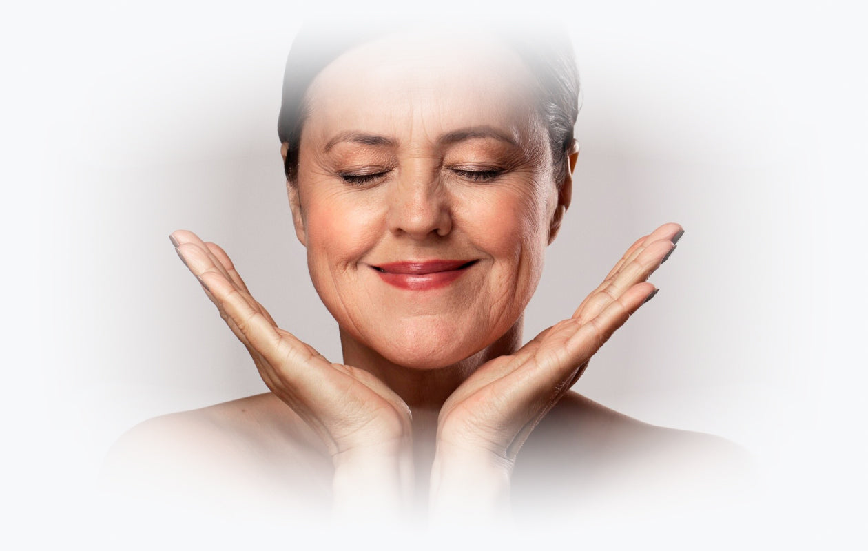 Image of woman smiling with her eyes closed and hands held under her chin and jaw line