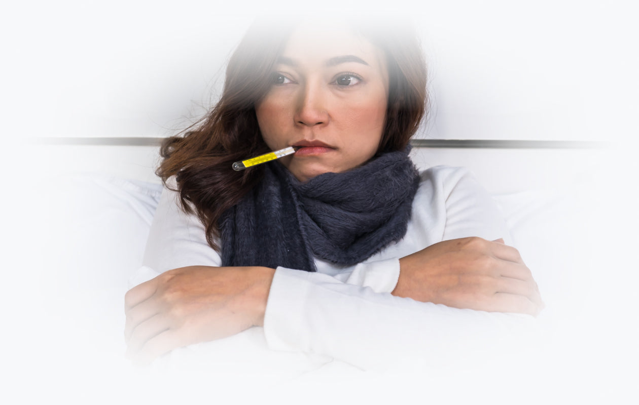 Woman with thermometer in her mouth feeling Chills from flu