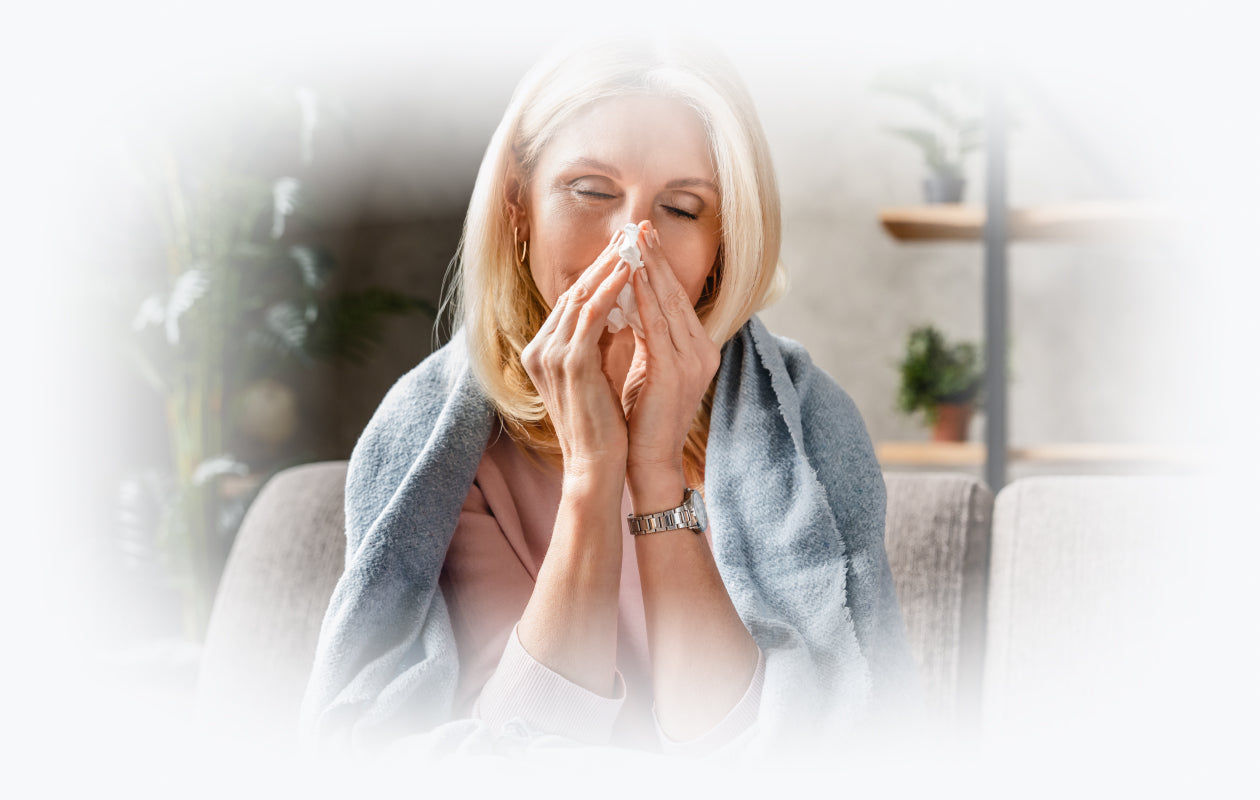 Image of woman blowing nose with tissue.