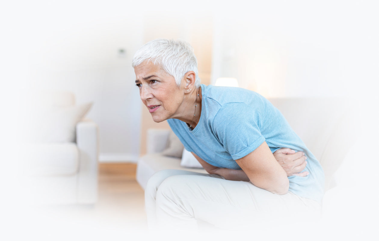 Image of woman on couch experiencing constipation.