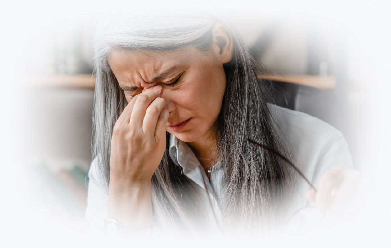 Image of woman holding hand to eyes for dry eyes.