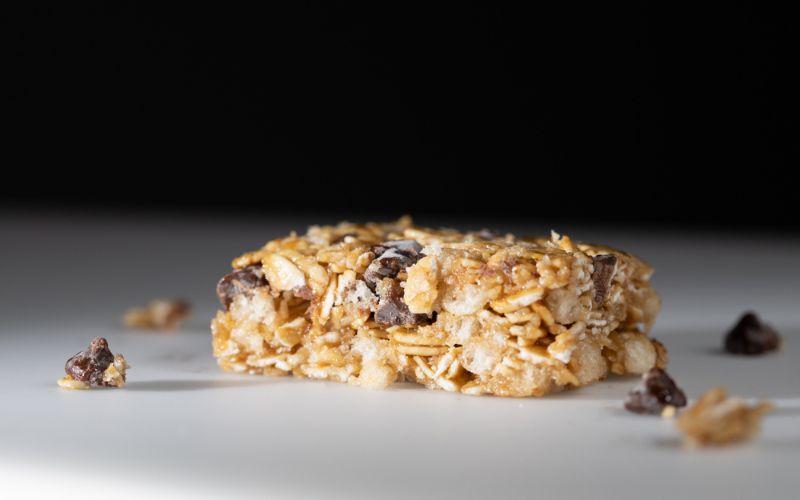 This is a picture of our Chewy Dark Chocolate Chip Granola Bars (Homemade with Rolled Oats, Almonds, Honey) on a white plate