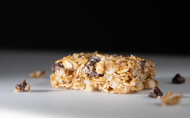 This is a picture of our Chewy Dark Chocolate Chip Granola Bars (Homemade with Rolled Oats, Almonds, Honey) on a white plate