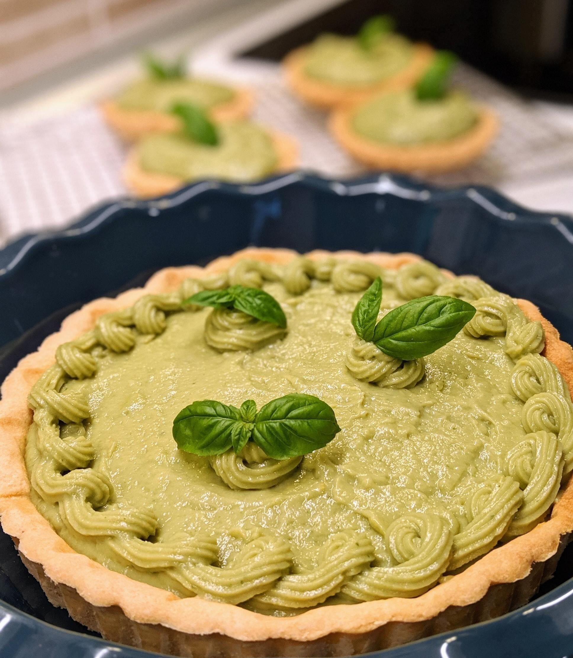 This is a picture of our Matcha Green Tea Coconut Avocado Pie in a black pie plate on a wooden countertop