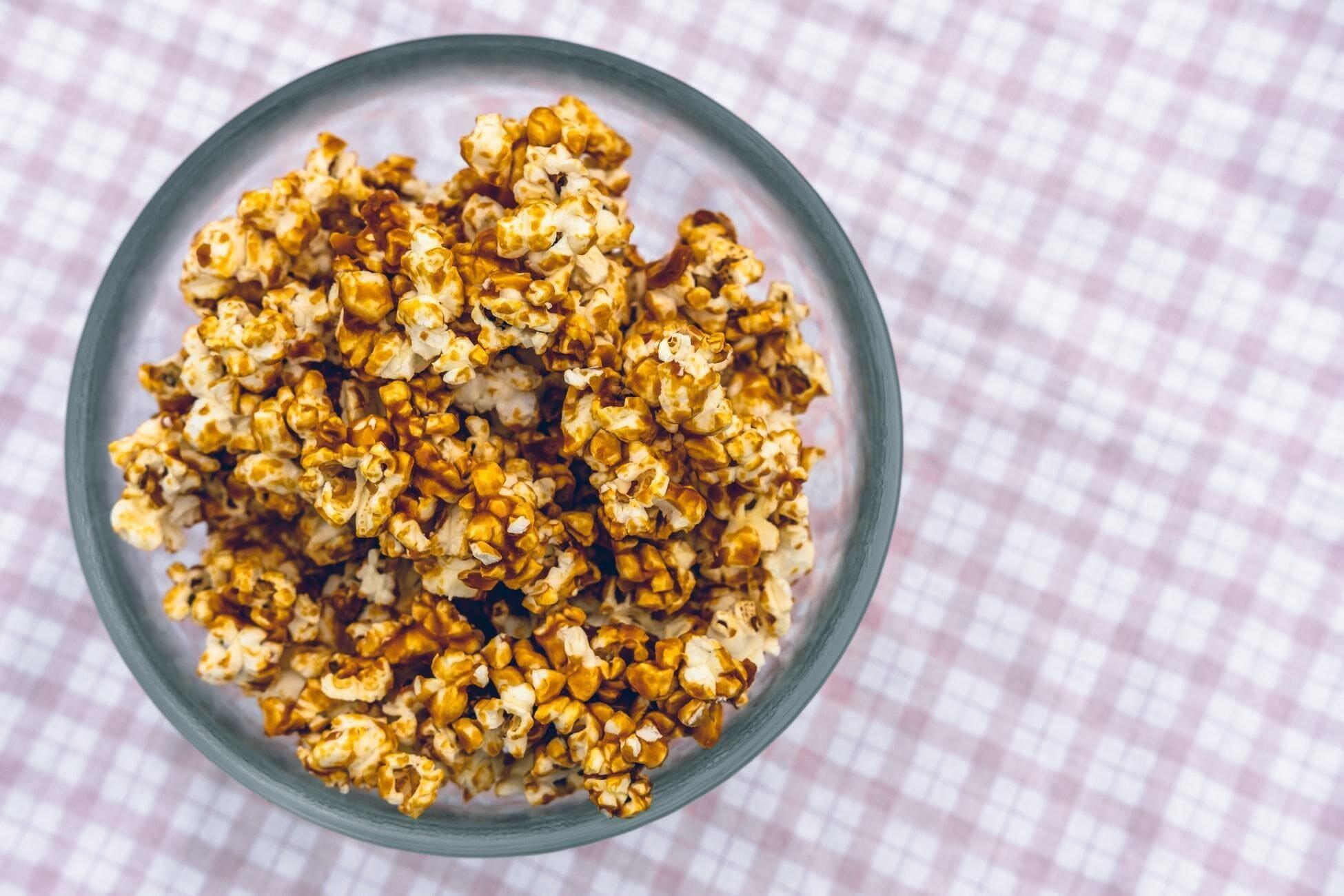 This is a picture of our Halloween Chocolate Popcorn balls in a ceramic bowl, on top of a checkered table cloth.