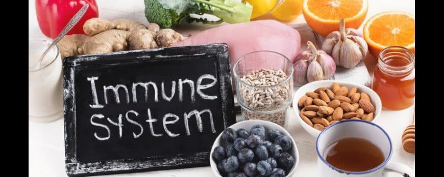 This a picture of a white board that says Immune System surrounded by many superfoods such as almonds, blueberries, sunflower seeds, oranges and more.