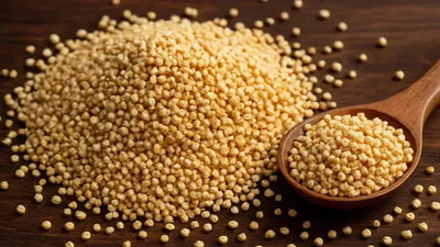 This is a picture of puffed quinoa on a wooden table, with a wooden spoon full next to it.