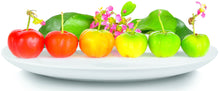Image of six Acerola Cherries aligned in a row with varying shades of ripeness.
