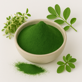Image of Alfalfa Juice powder in a white bowl surrounded by fresh Alfalfa leaves