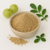 Image of Amla powder in a white bowl surrounded by leaves and fresh amla fruit