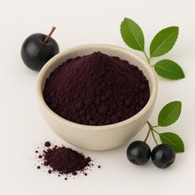 Image of Aronia berry powder in a white bowl with fresh aronia and leaves around it