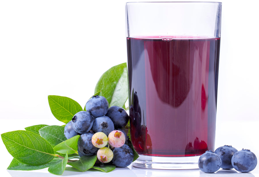 Clear glass of Blueberry Juice with actual blueberries on each side.