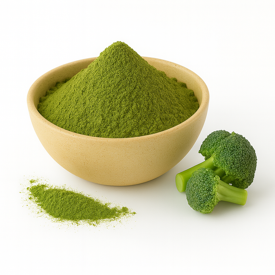 A beige bowl filled with green broccoli powder on a white background, with a small pile of powder and fresh broccoli florets beside it.