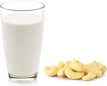 Glass of Cashew Milk next to several fresh Cashew nuts