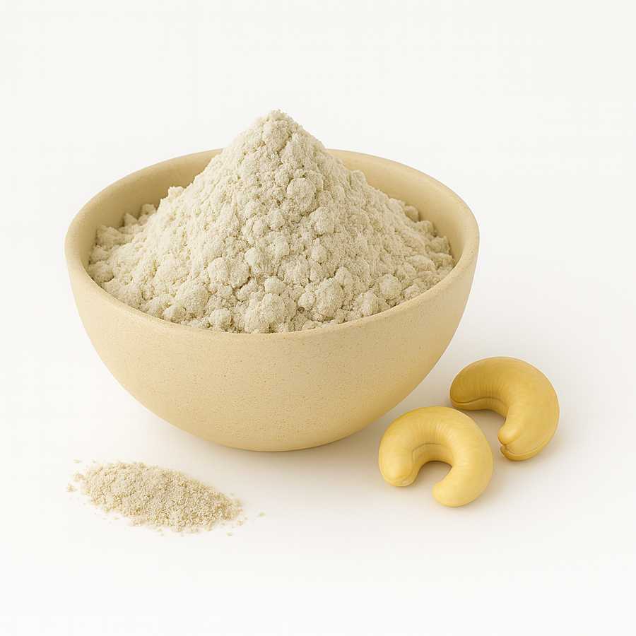 A bowl of cashew nut milk powder with two cashew nuts beside it on a white background.