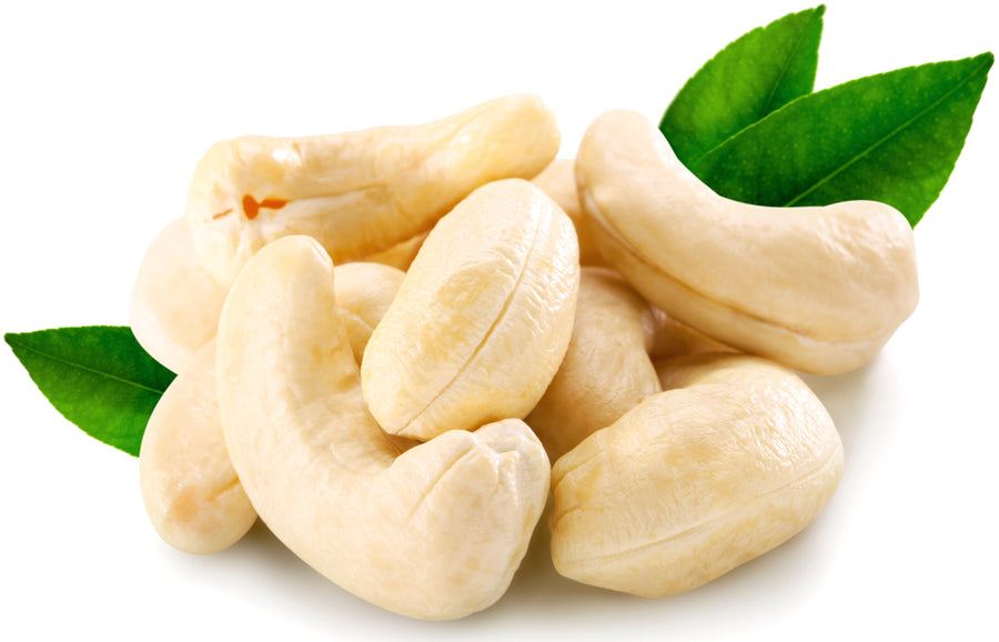 Image of whole cashews and green leaves