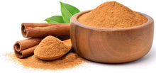 Image of 2 cassia Cinnamon sticks and powder inside a wooden bowl