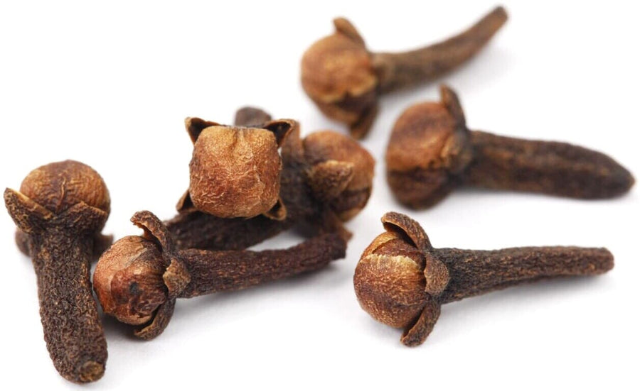 Cloves piled together on white background