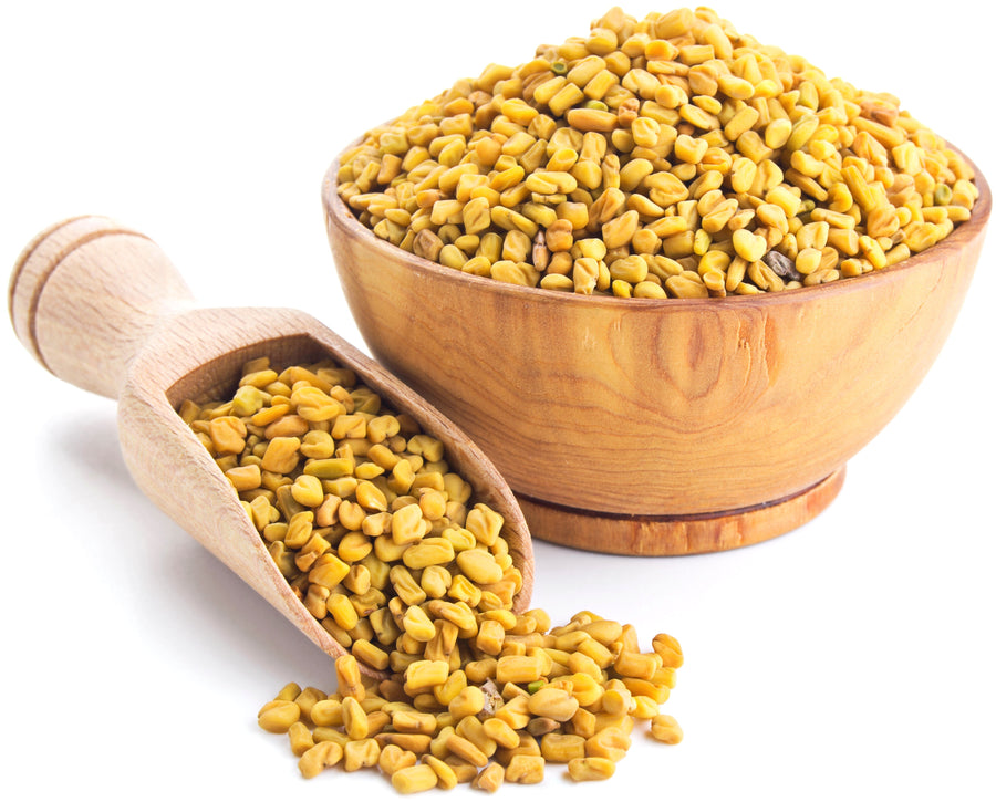 Image of wooden bowl containing Fenugreek Seeds next to wooden serving scoop with additional Fenugreek seeds in it.