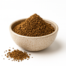Bowl of organic freeze-dried instant coffee granules on a white background