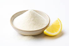 A bowl of organic lemon juice powder with a lemon slice on a white background.