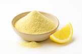 A bowl of organic freeze-dried lemon powder with a lemon slice on a white background.