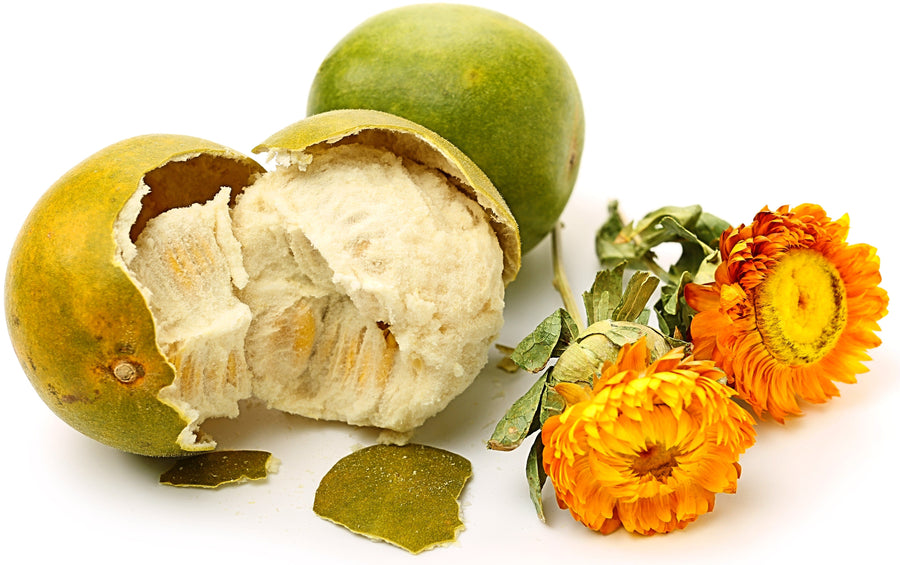 Image of a cracked and a whole green Luo Han Guo fruit and 2 orange flowers