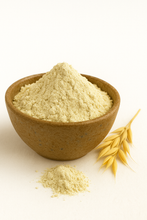 A bowl of organic oat milk powder with a small pile of powder in front and a golden oat stalk beside it on a white background.