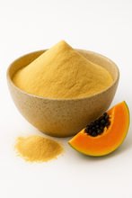 A bowl of organic papaya juice powder with a small pile of powder in front and a fresh papaya slice beside it.