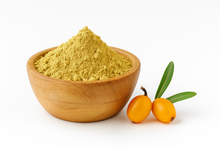 Beige color powder in a wooden bowl next to a pair of sea buckthorn berries.