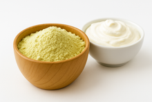 White creamy powder in wooden bowl next to sour cream in white bowl.