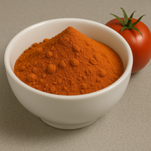 Red powder inside a white bowl next to a tomato.