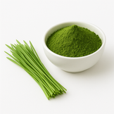 White bowl full of wheatgrass juice powder with fresh wheatgrass next to it