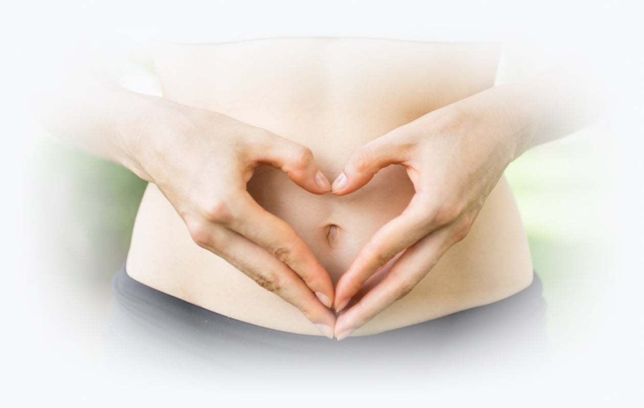 Image of woman making heart with her hands over her stomach to depict colon health