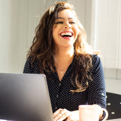 image of Woman using laptop and laughing